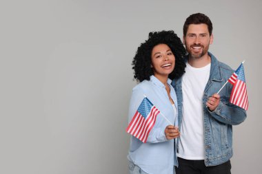 4 Temmuz - ABD 'nin Bağımsızlık Günü. Gri arka planda Amerikan bayrakları olan mutlu çift, mesaj için alan