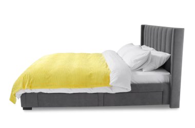 Beyaz arka planda çarşafları olan rahat gri yatak.