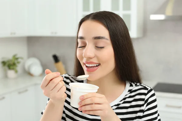 幸せな女性食べるおいしいヨーグルトでキッチン — ストック写真