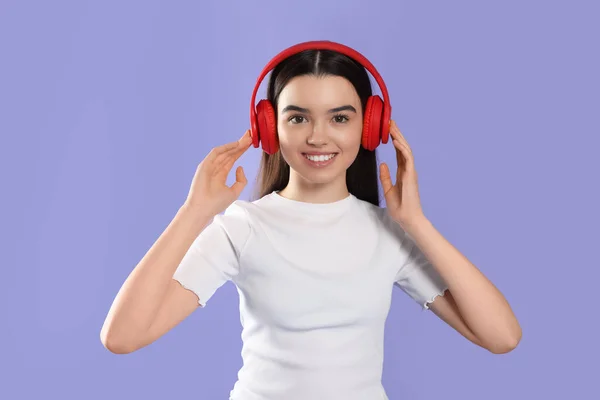 Adolescente Escuchando Música Con Auriculares Sobre Fondo Violeta — Foto de Stock