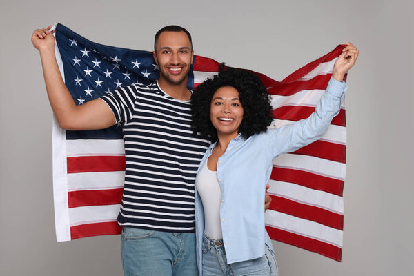 4th of July - Independence Day of USA. Happy couple with American flag on grey background