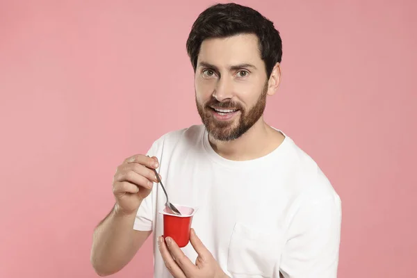 Pohledný Muž Lahodným Jogurtem Lžičkou Růžovém Pozadí — Stock fotografie