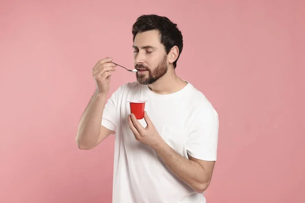 Pohledný Muž Jíst Lahodný Jogurt Růžovém Pozadí — Stock fotografie