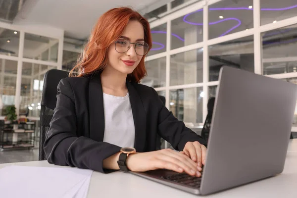 オフィスのホワイトデスクでノートパソコンを扱う女性 — ストック写真