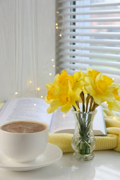 Beautiful Yellow Daffodils Vase Cup Coffee Book Festive Lights Windowsill — Stock Photo, Image