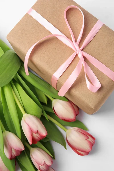 漂亮的礼品盒 白色背景上有蝴蝶结和粉红郁金香 — 图库照片