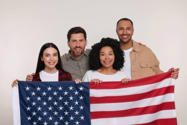 4 Temmuz - ABD 'nin Bağımsızlık Günü. Beyaz arka planda Amerikan bayrağı taşıyan mutlu arkadaşlar
