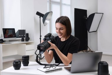 Modern fotoğraf stüdyosunda kamerası olan genç profesyonel fotoğrafçı.