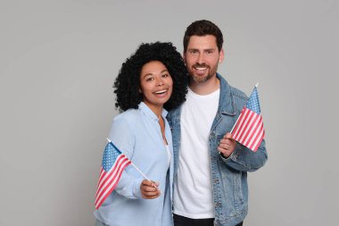 4 Temmuz - ABD 'nin Bağımsızlık Günü. Gri arka planda Amerikan bayrakları olan mutlu çift