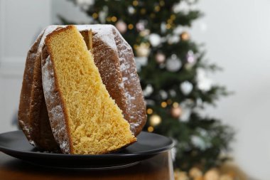 Noel ağacının yanında pudra şekerle süslenmiş leziz Pandoro pastası. Mesaj için yer var. Geleneksel İtalyan pastası