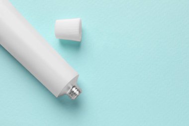 Açık mavi arka planda merhem tüpü, düz. Metin için boşluk