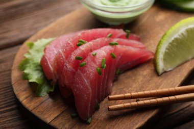 Lezzetli sashimi (yeşil soğanlı taze çiğ ton balığı parçaları) ve ahşap tahta çubuklar, yakın plan