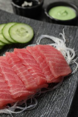 Lezzetli sashimi (taze çiğ ton balığı parçaları) ve tabakta cam erişte, yakın plan.