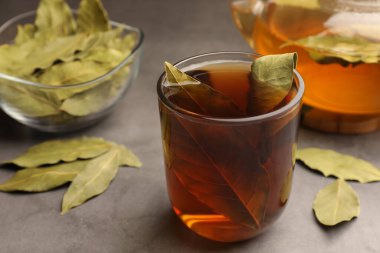 Gri masa üzerinde koyu yapraklı taze demlenmiş çay, yakın plan.