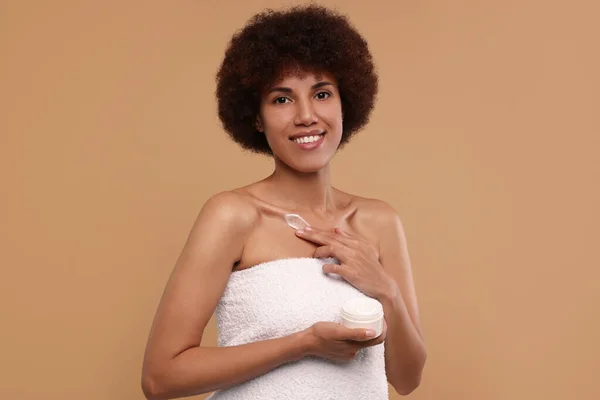 Mooie Jonge Vrouw Aanbrengen Crème Lichaam Beige Achtergrond — Stockfoto