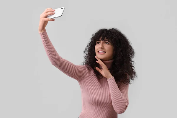 Hermosa Mujer Joven Tomando Selfie Sobre Fondo Gris Claro — Foto de Stock