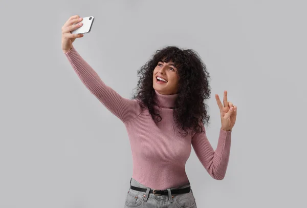 Όμορφη Νεαρή Γυναίκα Που Παίρνει Selfie Ανοιχτό Γκρι Φόντο — Φωτογραφία Αρχείου