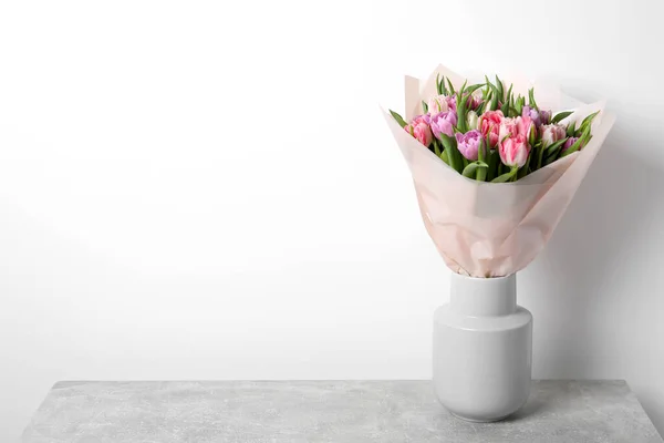 stock image Vase with bouquet of beautiful tulips on grey table. Space for text