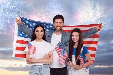 4 Temmuz - Amerika 'nın Bağımsızlık Günü. Mutlu aile, ABD bayraklarını havai fişeklerle havada tutuyor.