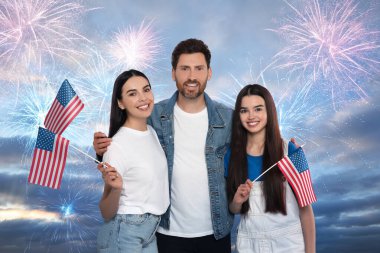 4 Temmuz - Amerika 'nın Bağımsızlık Günü. Mutlu aile, ABD bayraklarını havai fişeklerle havada tutuyor.