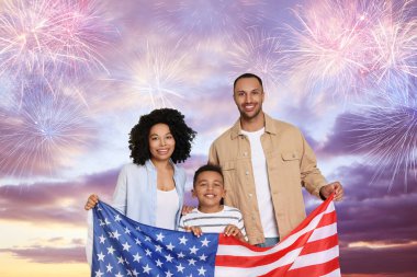 4 Temmuz - Amerika 'nın Bağımsızlık Günü. Mutlu aile, ABD bayrağını havai fişeklerle havada tutuyor.