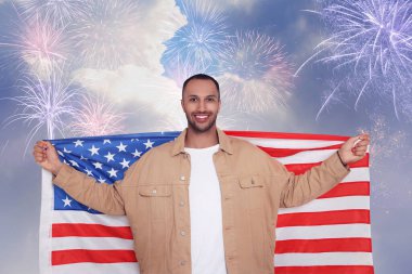 4 Temmuz - Amerika 'nın Bağımsızlık Günü. Amerika Birleşik Devletleri bayrağını havai fişeklerle havada tutan mutlu adam.