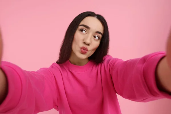 Νεαρή Γυναίκα Παίρνει Selfie Και Φυσάει Φιλί Ροζ Φόντο — Φωτογραφία Αρχείου