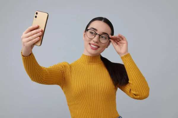 Jeune Femme Souriante Prenant Selfie Avec Smartphone Sur Fond Gris — Photo