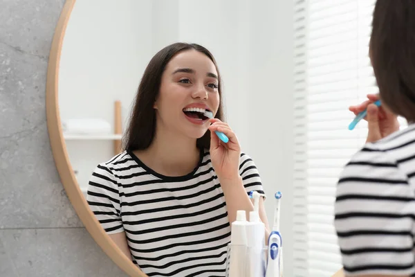 Jonge Vrouw Poetsen Haar Tanden Met Plastic Tandenborstel Buurt Spiegel — Stockfoto