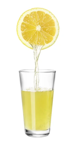 レモンの絞りたてのジュースを白い背景にガラスに注ぐ — ストック写真