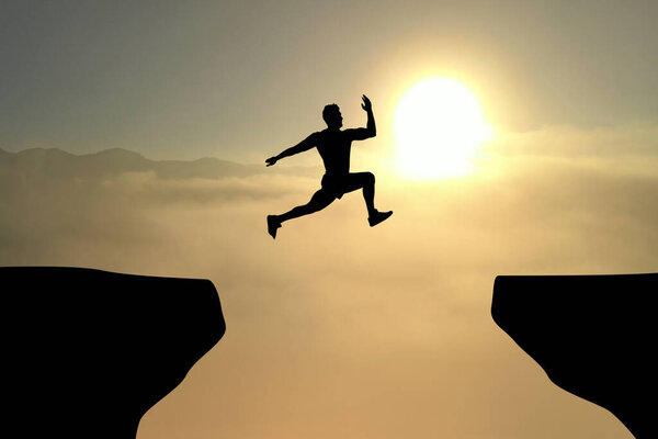 Концепция достижения жизненных и деловых целей. Силуэт человека, прыгающего через пропасть на восходе солнца