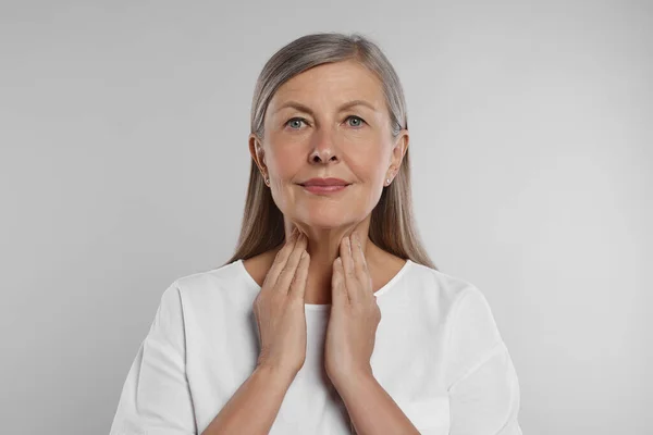 Sistem Endocrine Wanita Senior Melakukan Pemeriksaan Diri Tiroid Pada Latar — Stok Foto