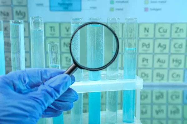 Laborassistentin Blickt Durch Lupe Auf Reagenzgläser Gegen Periodensystem Chemischer Elemente — Stockfoto