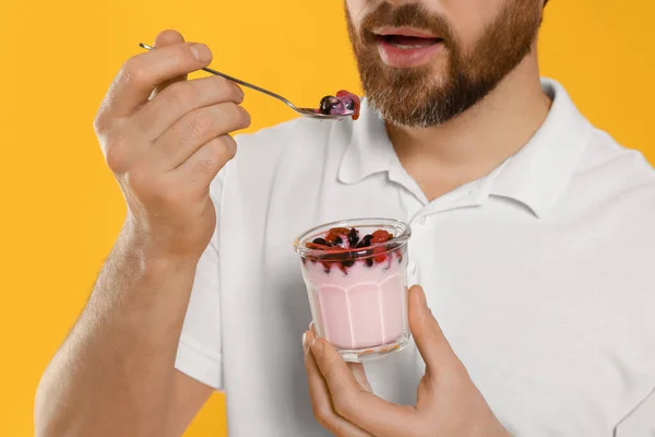 Man Eating Delicious Yogurt Yellow Background Closeup — Stock Photo, Image