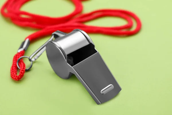 stock image One metal whistle with red cord on light green background, closeup