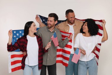 4 Temmuz - ABD 'nin Bağımsızlık Günü. Beyaz arka planda Amerikan bayrakları olan mutlu arkadaşlar