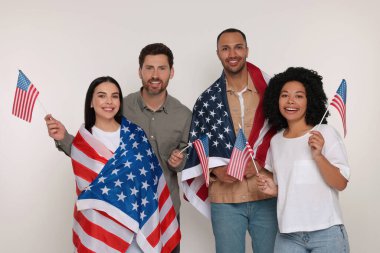 4 Temmuz - ABD 'nin Bağımsızlık Günü. Beyaz arka planda Amerikan bayrakları olan mutlu arkadaşlar