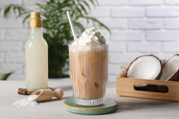 おいしいシロップのボトル アイスコーヒーのガラス 白い木製のテーブルのココナッツとフレークの半分 — ストック写真