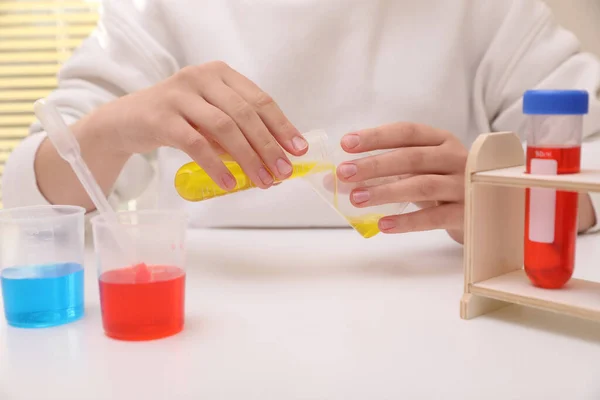 白いテーブルの屋内でカラフルな液体を混合女の子 閉じます 子供のための化学実験セット — ストック写真