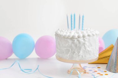 Beyaz masa üzerinde mumlar ve süslemeler olan lezzetli bir pasta. Metin için boşluk