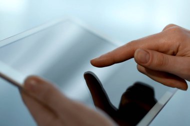Bulanık arkaplanda modern tablet kullanan kadının yakın görüntüsü