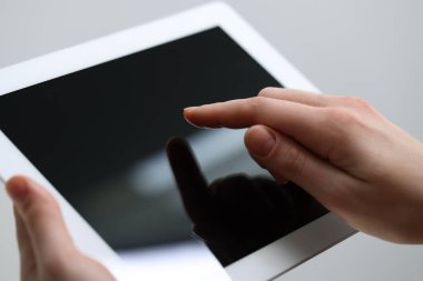 Açık gri arka planda modern tablet kullanan kadının yakın görüntüsü