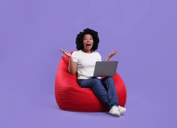 Emotionale Junge Frau Mit Laptop Auf Sitzsack Stuhl Vor Lila — Stockfoto