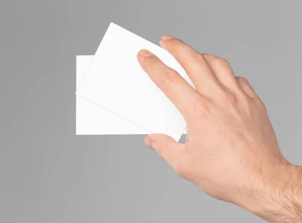 Man Holding Paper Cards Grey Background Closeup Mockup Design — Stock Photo, Image