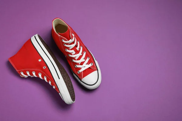 Een Paar Nieuwe Stijlvolle Rode Sneakers Een Paarse Achtergrond Plat — Stockfoto