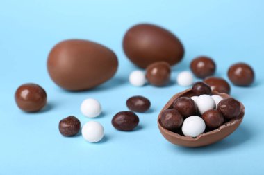 Açık mavi arka planda farklı tatlılar olan lezzetli çikolatalı yumurtalar. Metin için boşluk