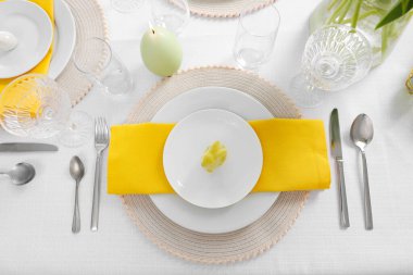 Çatal bıçak, tabak ve tavşan figürlü şenlik masası, düz yatak. Paskalya kutlaması