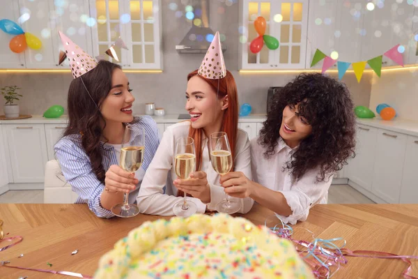 幸せな若いですおいしいケーキとスパークリングワインのメガネを持つ女性はキッチンで誕生日を祝う — ストック写真