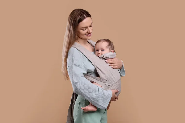Moeder Houdt Haar Kind Draagdoek Babydrager Lichtbruine Achtergrond — Stockfoto