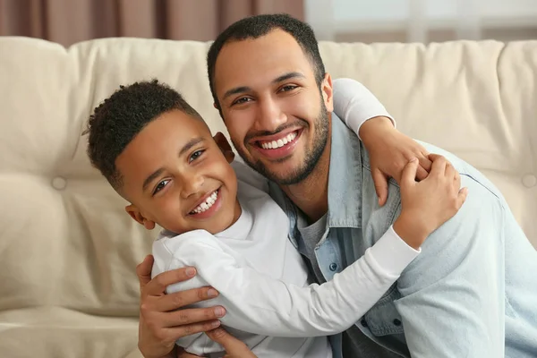 stock image Father with his African American son on sofa. International family